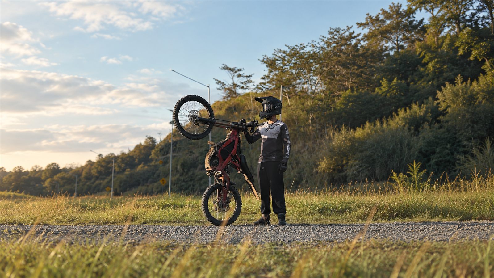 Rider con dirt bike eléctrica al atardecer